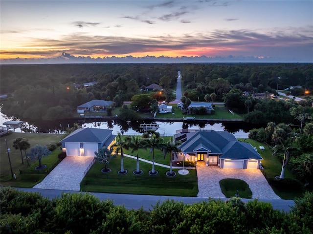 aerial view at dusk featuring a water view