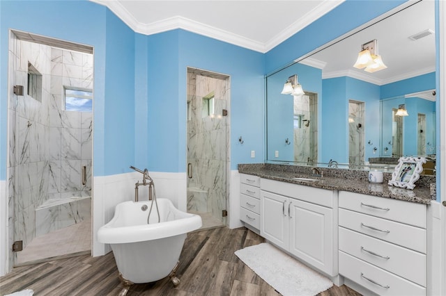 bathroom with plus walk in shower, ornamental molding, hardwood / wood-style floors, and vanity