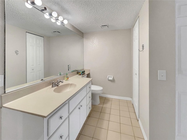 bathroom featuring vanity, tile patterned floors, a textured ceiling, and toilet