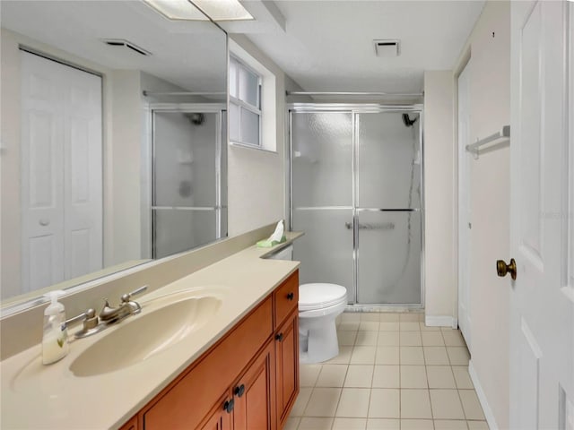 bathroom with tile patterned flooring, walk in shower, toilet, and vanity