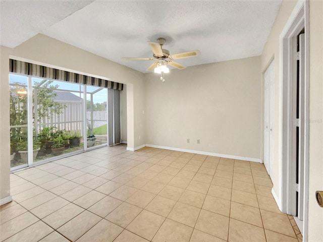 unfurnished room featuring a textured ceiling, ceiling fan, and light tile patterned floors