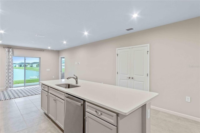 kitchen featuring a sink, visible vents, light countertops, stainless steel dishwasher, and an island with sink