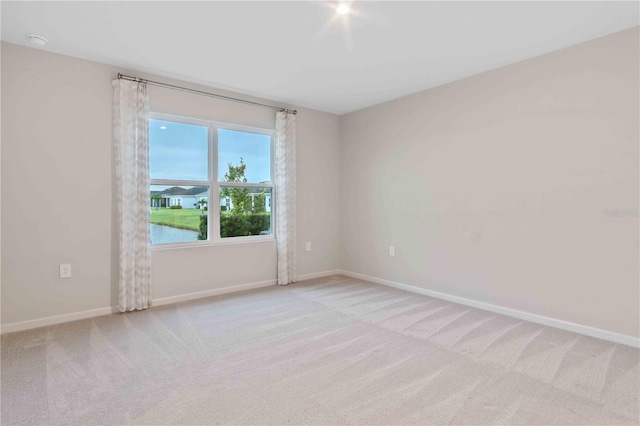 unfurnished room featuring baseboards and light colored carpet