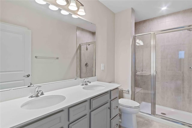 full bathroom featuring double vanity, a sink, toilet, and a shower stall