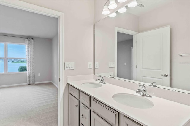 bathroom featuring double vanity, visible vents, baseboards, and a sink