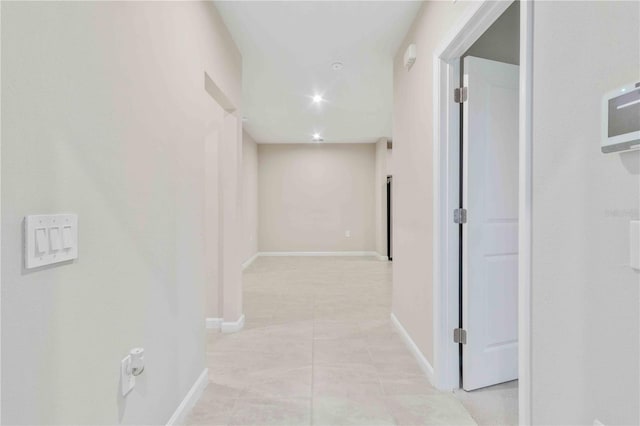 hall with light tile patterned floors and baseboards