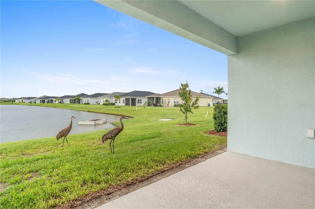 view of yard with a residential view and a water view