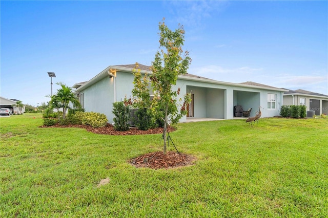 back of property featuring central air condition unit, a patio area, a lawn, and stucco siding