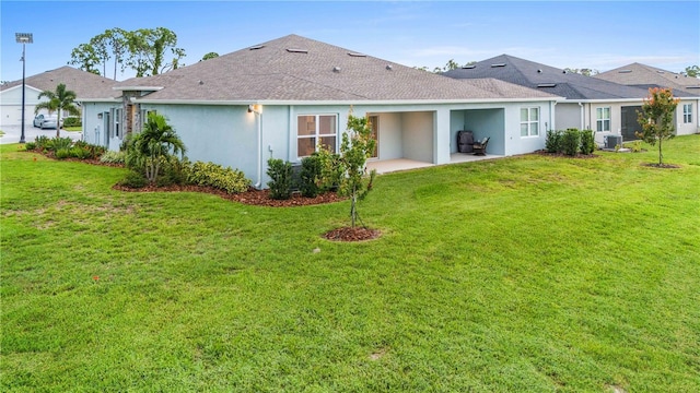 back of house with a patio area, stucco siding, central AC, and a yard