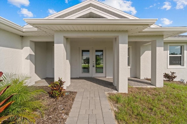 view of exterior entry featuring a patio area and french doors