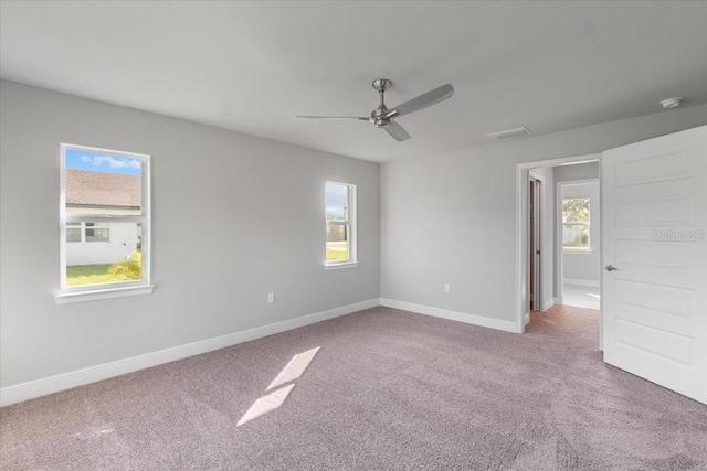 empty room with carpet, ceiling fan, and a wealth of natural light