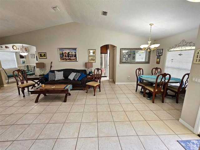 tiled living room with a notable chandelier and vaulted ceiling