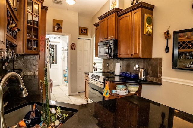 kitchen with stainless steel electric range, light tile patterned floors, sink, and tasteful backsplash