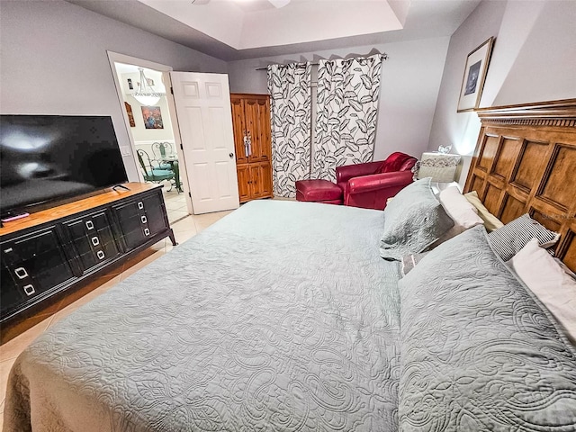 bedroom featuring a raised ceiling and light hardwood / wood-style flooring