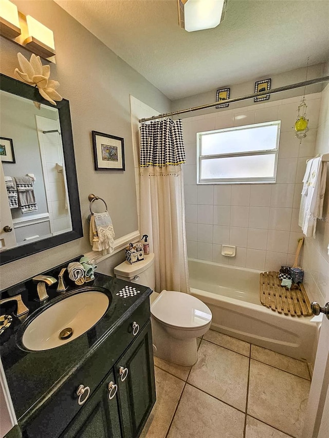 full bathroom featuring vanity, toilet, a textured ceiling, tile patterned flooring, and shower / tub combo with curtain