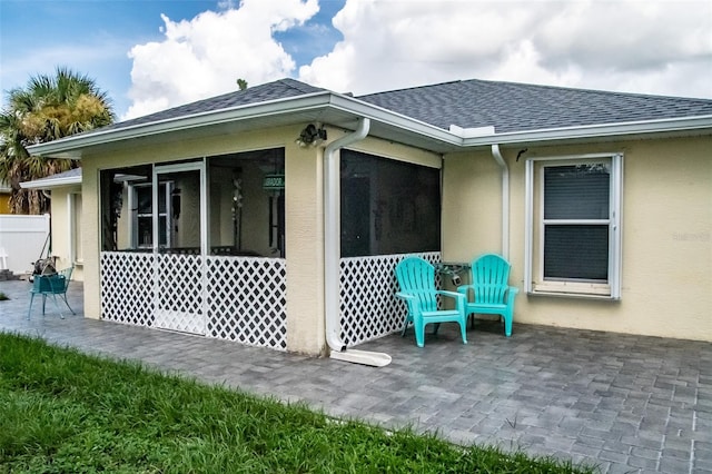 view of side of home with a sunroom and a patio