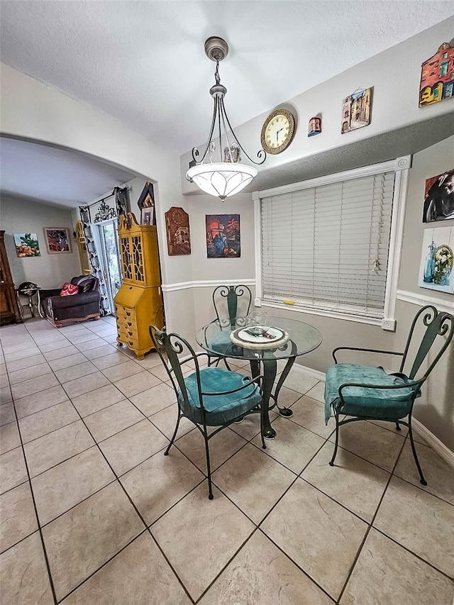 dining area with a textured ceiling and light tile patterned floors