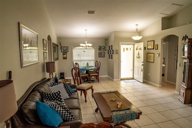 tiled living room featuring an inviting chandelier and vaulted ceiling