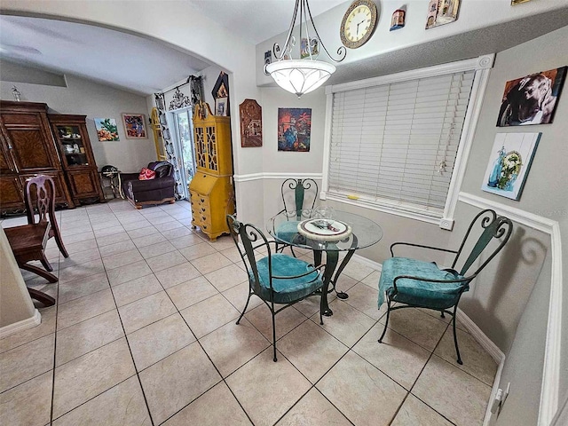 dining space with light tile patterned flooring and lofted ceiling