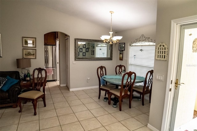 tiled dining area with vaulted ceiling and a notable chandelier