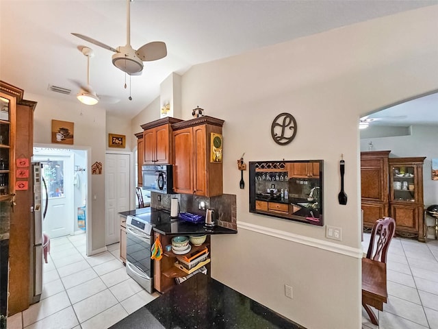 kitchen with refrigerator, stainless steel electric range, backsplash, and light tile patterned flooring