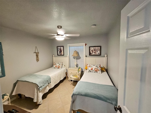 bedroom featuring a textured ceiling, ceiling fan, and light tile patterned floors