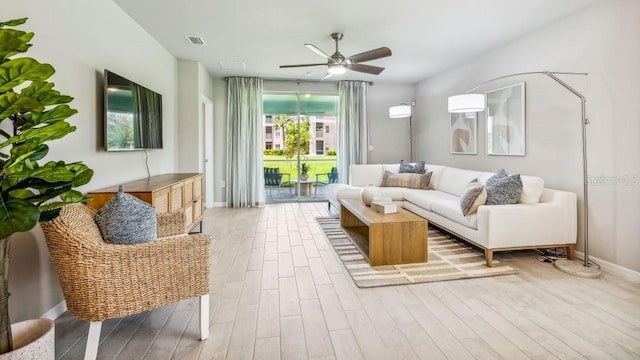 living room featuring ceiling fan and light hardwood / wood-style floors