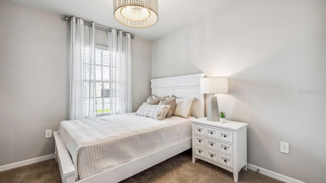 bedroom with multiple windows and dark carpet