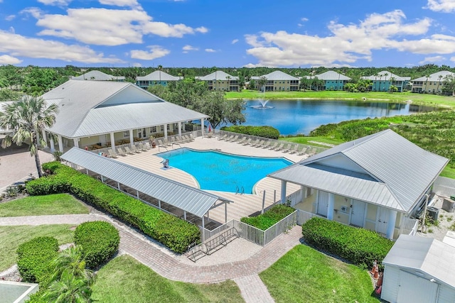 view of swimming pool with a yard, a water view, and a patio area