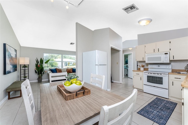 tiled dining room with sink and high vaulted ceiling