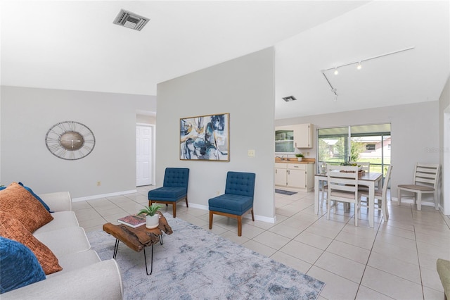 tiled living room featuring rail lighting and vaulted ceiling