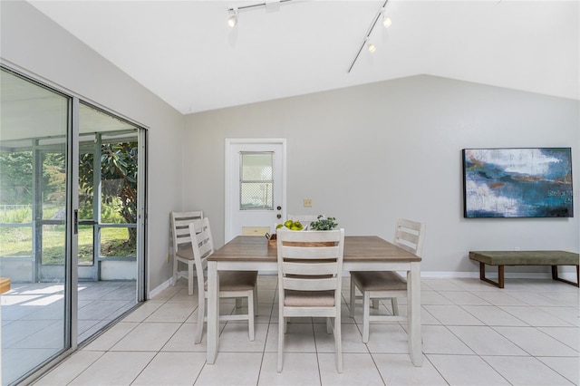 dining area featuring a wealth of natural light, lofted ceiling, track lighting, and light tile patterned flooring