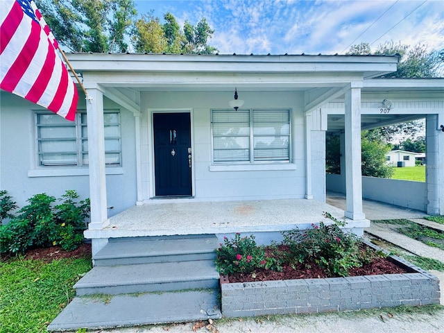 view of exterior entry featuring covered porch