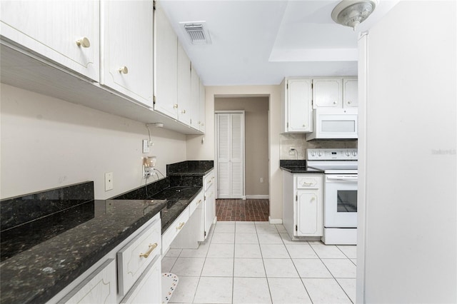 kitchen with white cabinets, dark stone counters, light hardwood / wood-style flooring, and white appliances