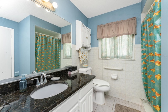 bathroom featuring vanity, tile patterned flooring, a textured ceiling, tile walls, and toilet