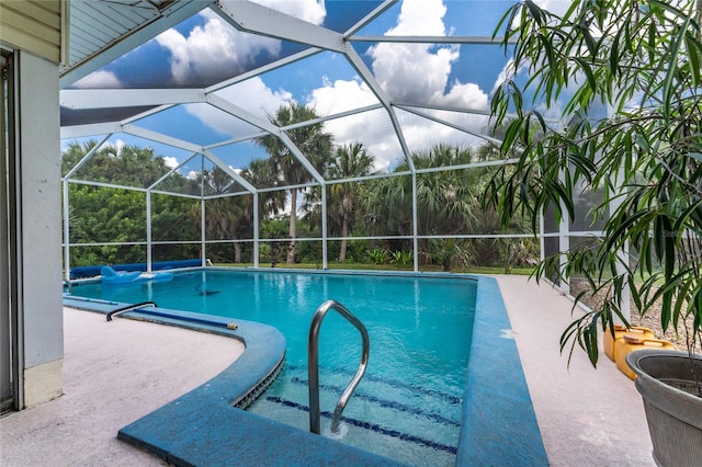 view of swimming pool featuring a patio and a lanai