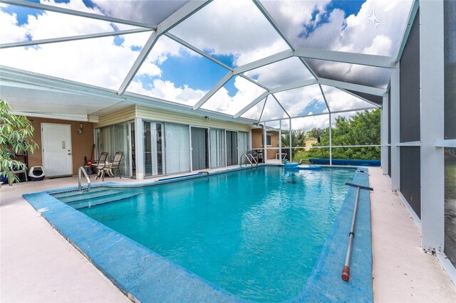 view of swimming pool featuring a patio and a lanai