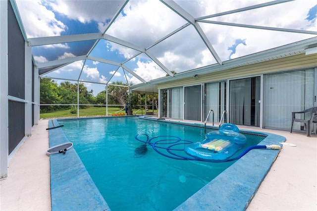 view of pool featuring glass enclosure and a patio