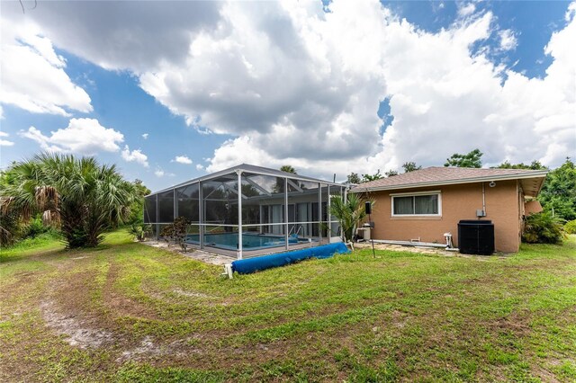 exterior space with a lanai, central AC unit, and a covered pool