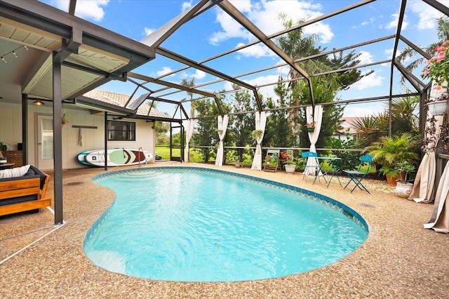 view of pool featuring glass enclosure and a patio