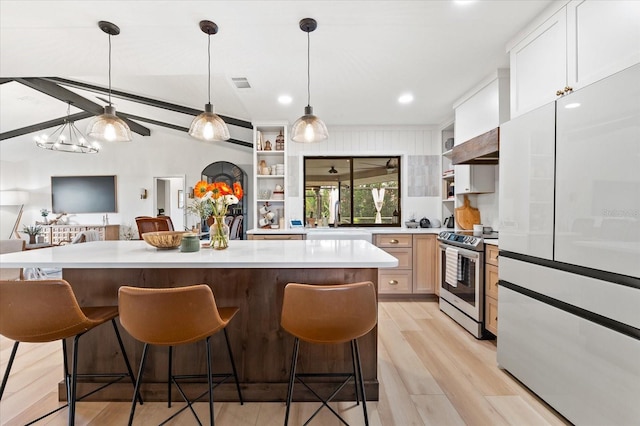 kitchen featuring a breakfast bar, decorative light fixtures, a center island, stainless steel electric stove, and white cabinets