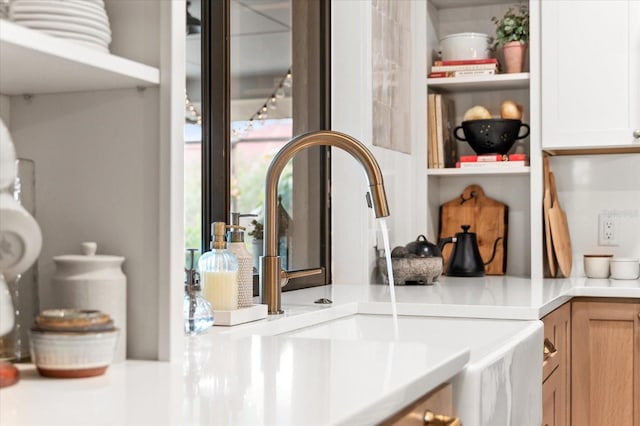 interior details featuring white cabinetry, sink, and light brown cabinets