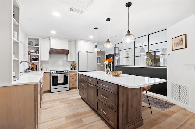 kitchen with premium range hood, a center island, a breakfast bar area, and stainless steel range with electric stovetop