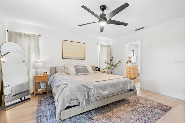 bedroom with ensuite bathroom, ceiling fan, and light hardwood / wood-style flooring