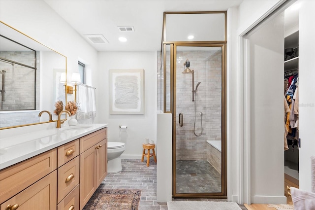 bathroom featuring vanity, toilet, and walk in shower