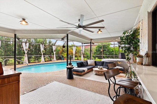 view of swimming pool with ceiling fan, an outdoor living space, a lanai, and a patio