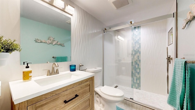 bathroom featuring toilet, a stall shower, visible vents, and vanity