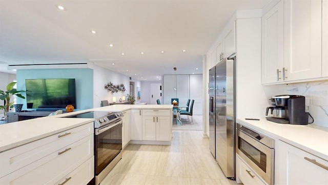 kitchen featuring white cabinetry, backsplash, appliances with stainless steel finishes, and light tile patterned floors