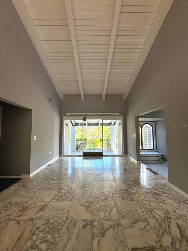 tiled empty room featuring wooden ceiling, beamed ceiling, and high vaulted ceiling