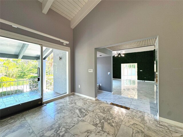 tiled spare room with beam ceiling, high vaulted ceiling, and a wealth of natural light